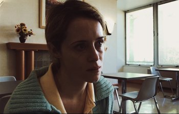 Movie still from “Unsane” (2018), directed by Steven Soderbergh – A woman sitting at a table in front of a window; Close Up shot, Over the shoulder angle