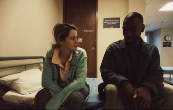 Movie still from “Unsane” (2018), directed by Steven Soderbergh – A woman and a man sitting on a bed in front of a toilet; Medium shot, Over the shoulder angle
