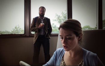 Movie still from “Unsane” (2018), directed by Steven Soderbergh – A man and a woman in front of a large window; Medium shot, Over the shoulder angle