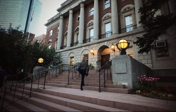 Movie still from “Unsane” (2018), directed by Steven Soderbergh – A person walking down the steps of a building; Extreme Wide shot, Low angle