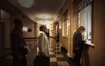 Movie still from “Unsane” (2018), directed by Steven Soderbergh – Three people are walking in a hallway of a building; Wide shot, Low angle