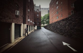 Movie still from “Unsane” (2018), directed by Steven Soderbergh – A man walking down a street in the middle of the day; Extreme Wide shot, High angle