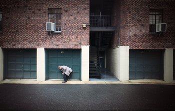Movie still from “Unsane” (2018), directed by Steven Soderbergh – A man is leaning against a garage door; Extreme Wide shot, High angle