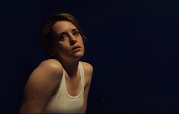Movie still from “Unsane” (2018), directed by Steven Soderbergh – A woman in a white tank top is looking up; Close Up shot, High angle