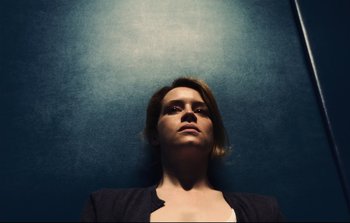 Movie still from “Unsane” (2018), directed by Steven Soderbergh – A woman with her head up in the air; Close Up shot, Overhead angle