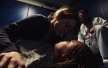 Movie still from “Unsane” (2018), directed by Steven Soderbergh – A woman and a man are laying on a bed together; Medium shot, Over the shoulder angle