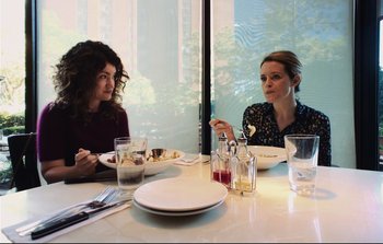 Movie still from “Unsane” (2018), directed by Steven Soderbergh – Two women sitting at a table with plates of food in front of them; Medium shot, Over the shoulder angle
