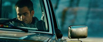 Movie still from “Unstoppable” (2010), directed by Tony Scott – A man sitting in the driver's seat of a car; Close Up shot, Over the shoulder angle