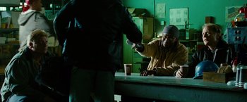Movie still from “Unstoppable” (2010), directed by Tony Scott – A man sitting at a table with a cup of coffee; Medium shot, Over the shoulder angle
