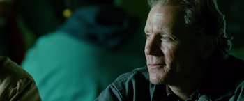 Movie still from “Unstoppable” (2010), directed by Tony Scott – An older man sitting in front of a green wall; Close Up shot, Over the shoulder angle