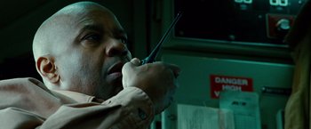 Movie still from “Unstoppable” (2010), directed by Tony Scott – A man holding a walkie talkie up to his mouth; Close Up shot, Low angle
