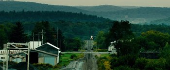 Movie still from “Unstoppable” (2010), directed by Tony Scott – A train traveling down train tracks near a forest; Extreme Wide shot, High angle