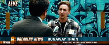 Movie still from “Unstoppable” (2010), directed by Tony Scott – A man in a plaid shirt talking to a man in a black suit; Medium shot, Over the shoulder angle