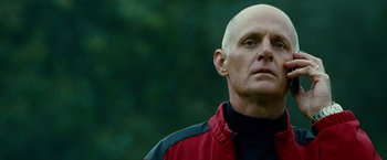Movie still from “Unstoppable” (2010), directed by Tony Scott – A bald man in a red and black jacket; Close Up shot, Low angle