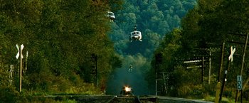 Movie still from “Unstoppable” (2010), directed by Tony Scott – A helicopter is flying over a train track and trees; Extreme Wide shot, High angle