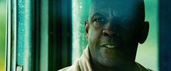 Movie still from “Unstoppable” (2010), directed by Tony Scott – A man's face in front of a window; Extreme Close Up shot, Low angle