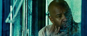 Movie still from “Unstoppable” (2010), directed by Tony Scott – A man with a bald head is sitting in front of a window; Close Up shot, Low angle