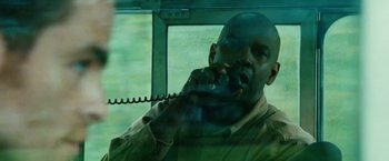 Movie still from “Unstoppable” (2010), directed by Tony Scott – A man talking on a phone while sitting in a vehicle; Close Up shot, Low angle