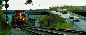Movie still from “Unstoppable” (2010), directed by Tony Scott – A train traveling down train tracks next to a bridge; Extreme Wide shot, High angle