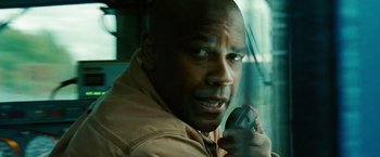 Movie still from “Unstoppable” (2010), directed by Tony Scott – A bald man holding a cell phone in his hand; Close Up shot, Low angle