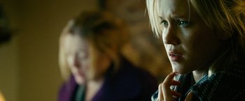Movie still from “Unstoppable” (2010), directed by Tony Scott – A woman is talking on a cell phone while another woman looks on in the background; Close Up shot, Over the shoulder angle