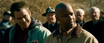 Movie still from “Unstoppable” (2010), directed by Tony Scott – A group of men standing next to each other on a field; Close Up shot, Over the shoulder angle