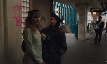 Movie still from “Until the End of the World” (1991), directed by Wim Wenders – Two women are standing in an alley; Medium shot, Low angle