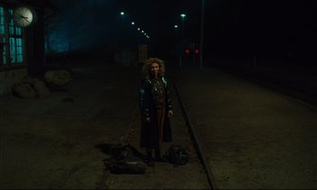 Movie still from “Until the End of the World” (1991), directed by Wim Wenders – A woman standing on a train track at night; Wide shot, High angle
