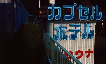 Movie still from “Until the End of the World” (1991), directed by Wim Wenders – A group of people standing next to each other on a bridge at night; Wide shot, Low angle