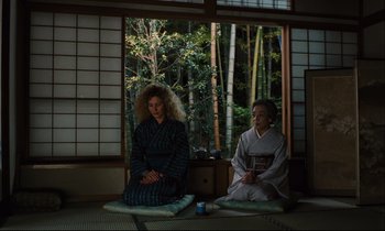 Movie still from “Until the End of the World” (1991), directed by Wim Wenders – Two women sitting in front of a window in a room; Wide shot, Low angle