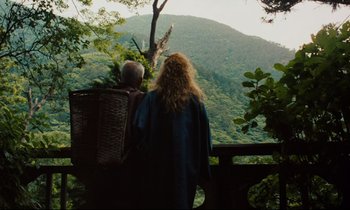 Movie still from “Until the End of the World” (1991), directed by Wim Wenders – A woman standing on top of a wooden platform; Wide shot, Low angle