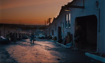 Movie still from “Until the End of the World” (1991), directed by Wim Wenders – Two people walking down the street at sunset; Wide shot, Over the shoulder angle