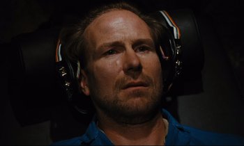 Movie still from “Until the End of the World” (1991), directed by Wim Wenders – A person wearing headphones; Close Up shot, Overhead angle