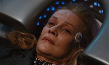Movie still from “Until the End of the World” (1991), directed by Wim Wenders – An older woman with blonde hair and a black and white dress; Close Up shot, High angle