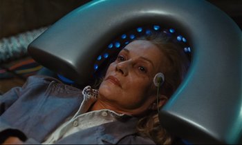 Movie still from “Until the End of the World” (1991), directed by Wim Wenders – A woman is sitting in an electric chair; Close Up shot, High angle