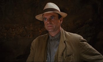Movie still from “Until the End of the World” (1991), directed by Wim Wenders – A man wearing a hat and a jacket; Close Up shot, Over the shoulder angle