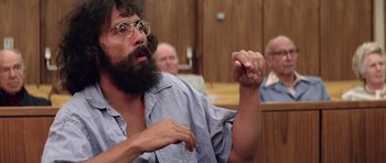 A man with a beard and glasses in a court room
