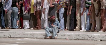 A man sitting on the ground in front of a group of onlookers