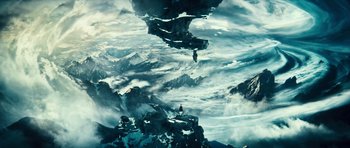 A man standing on top of a mountain looking up at the sky