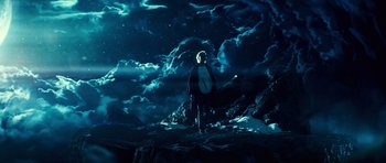 A person standing in the dark under a cloudy sky