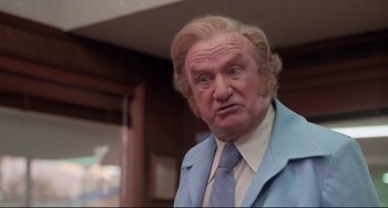 Movie still from “Used Cars” (1980), directed by Robert Zemeckis – An old man with blonde hair wearing a blue suit; Close Up shot, Low angle
