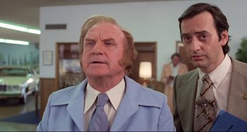 Movie still from “Used Cars” (1980), directed by Robert Zemeckis – An older man in a blue suit and a man in a blue tie; Close Up shot, Low angle