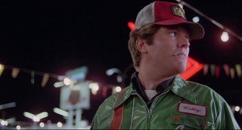 Movie still from “Used Cars” (1980), directed by Robert Zemeckis – A person wearing a jacket and a hat; Close Up shot, Low angle