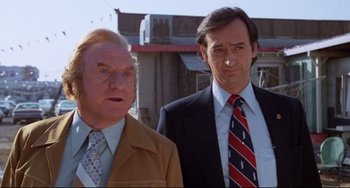 Movie still from “Used Cars” (1980), directed by Robert Zemeckis – Two men standing next to each other wearing suits and ties; Close Up shot, Low angle