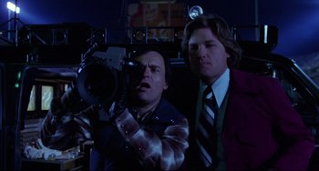 Movie still from “Used Cars” (1980), directed by Robert Zemeckis – Two men in a dark room with a movie camera; Medium shot, Low angle