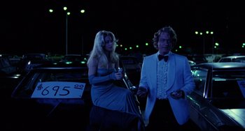 Movie still from “Used Cars” (1980), directed by Robert Zemeckis – A man and a woman dressed in formal wear; Medium shot, Over the shoulder angle