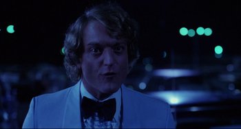 Movie still from “Used Cars” (1980), directed by Robert Zemeckis – A man in a white suit and a bow tie; Close Up shot, Low angle