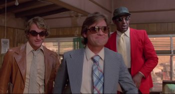 Movie still from “Used Cars” (1980), directed by Robert Zemeckis – A group of men standing next to each other wearing suits; Medium shot, Low angle