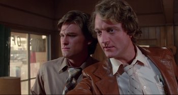 Movie still from “Used Cars” (1980), directed by Robert Zemeckis – A couple of men standing next to each other; Close Up shot, Low angle