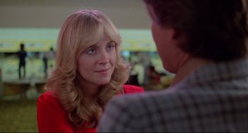 Movie still from “Used Cars” (1980), directed by Robert Zemeckis – A woman in a red jacket talking to a man in a plaid shirt; Close Up shot, Over the shoulder angle